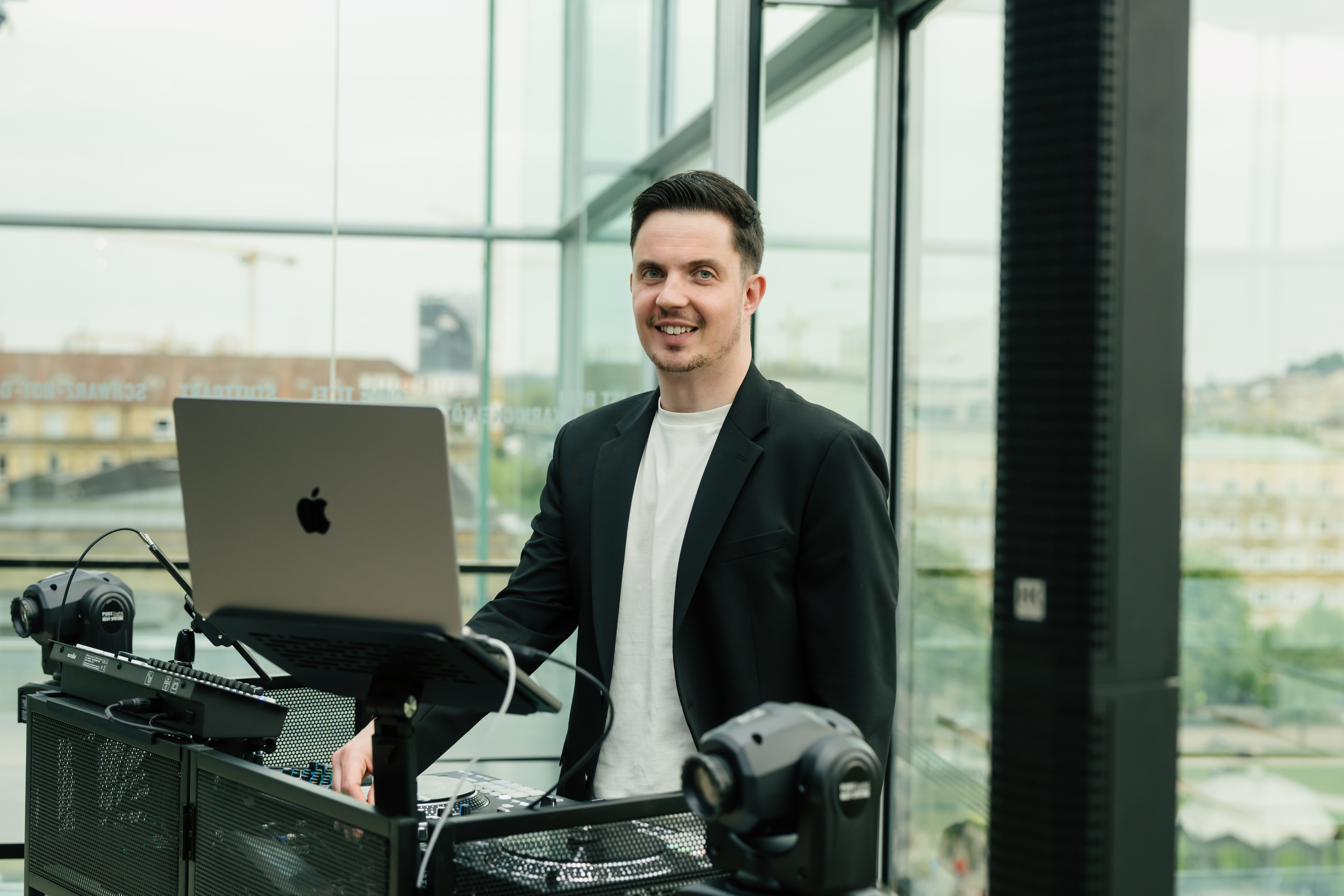 DJ Markus Holder am Pult in einer Eventlocation mit Blick über Stuttgart