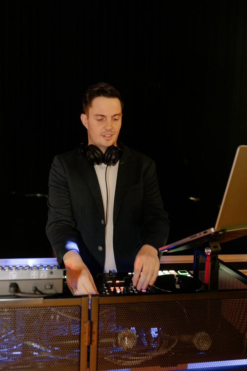 DJ Markus Holder am beleuchteten Pult bei einer Abendveranstaltung