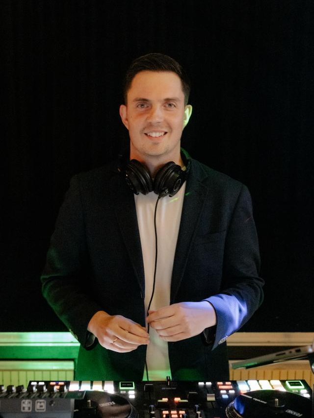 DJ Markus Holder aus dem Raum Stuttgart lächelnd am DJ-Pult mit Kopfhörern und Turntable-Controller